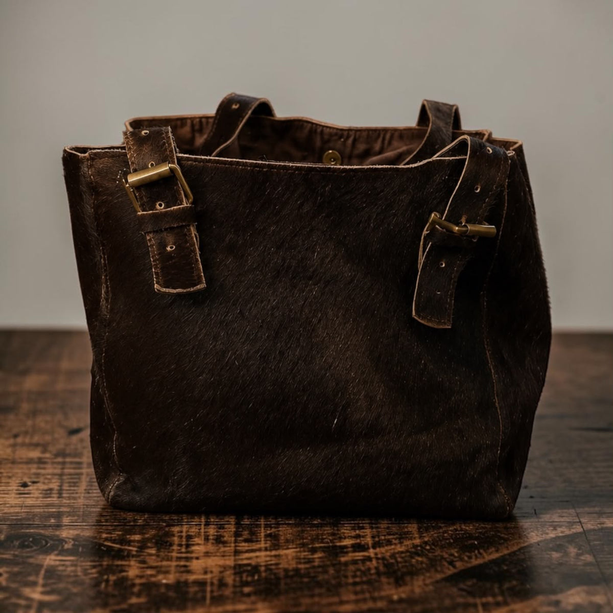 Brown hair-on genuine cowhide leather tote with brass hardware and leather straps