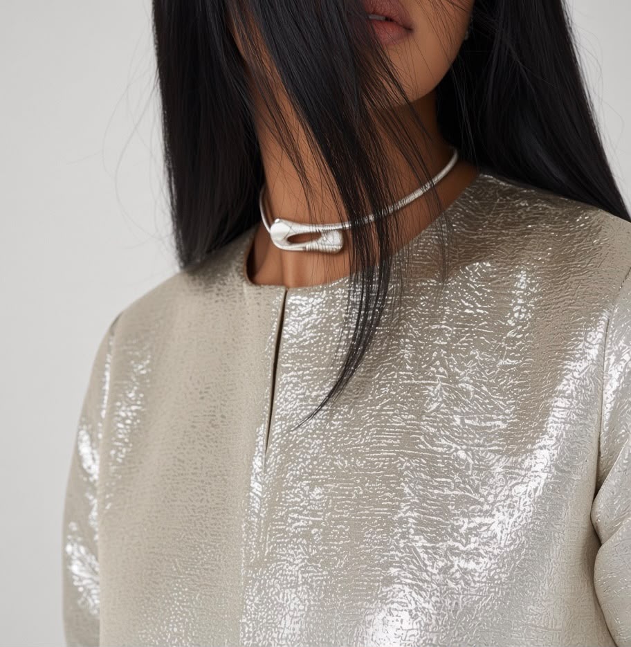 Close-up of a silver metallic kaftan neckline with a cuff necklace